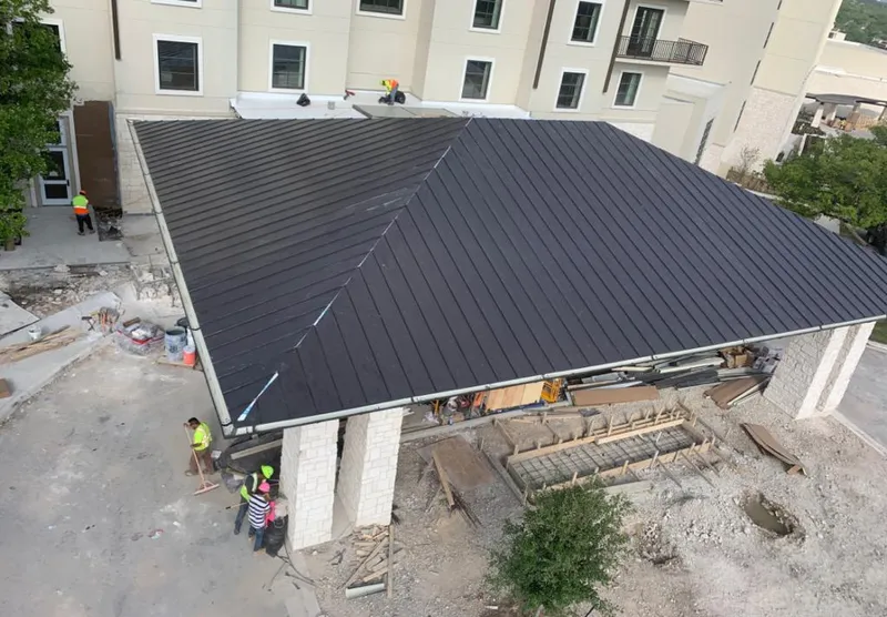 Metal roofing installation team working on a commercial building in Mount Airy